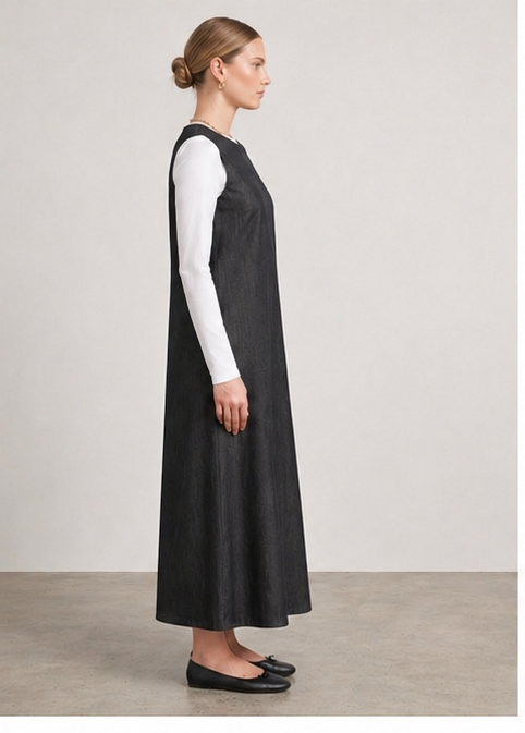 Black denim midi dress by MissFinchNYC shown from the side, full-length view highlighting its sleek, fitted silhouette.